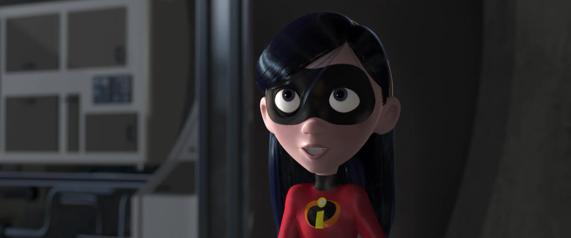 Personnage animé en 3D représentant une jeune fille aux grands yeux, vêtue d'un costume de super-héros rouge des Indestructibles, avec un masque noir et des cheveux noirs coupés au carré, debout dans ce qui semble être