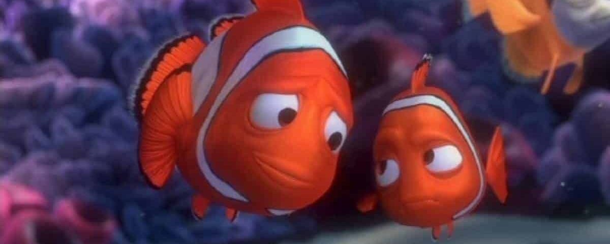 Une capture d'écran de Marlin et Nemo du film d'animation "Le Monde de Nemo", deux personnages de poissons-clowns nageant près d'un récif de corail, montrant des visages expressifs.