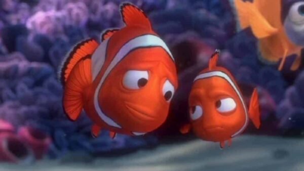 Une capture d'écran de Marlin et Nemo du film d'animation "Le Monde de Nemo", deux personnages de poissons-clowns nageant près d'un récif de corail, montrant des visages expressifs.