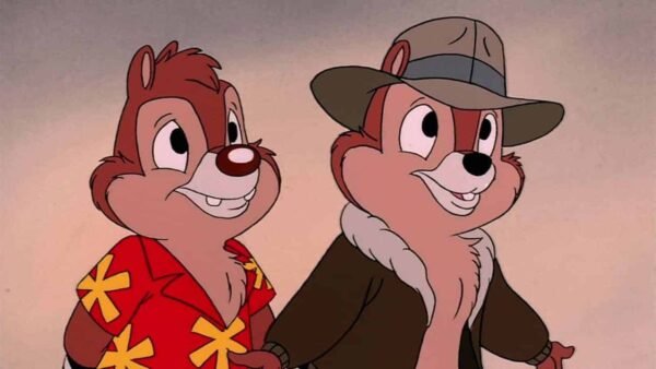 Deux tamias animés, l'un vêtu d'une chemise rouge à fleurs jaunes et l'autre portant une veste marron et un chapeau vert, souriant et debout côte à côte, sont connus sous le nom de Disney's Tic.