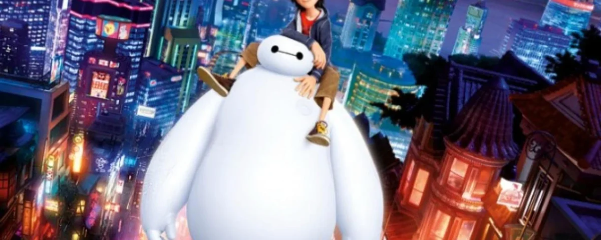 Personnages animés Hiro et Baymax du film d'animation "Les Nouveaux Héros" debout au-dessus d'un paysage urbain bien éclairé la nuit. Hiro est sur les épaules de Baymax, les deux