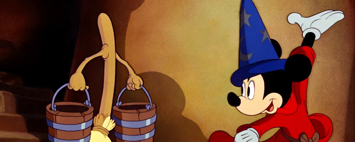 Mickey Mouse, habillé en apprenti sorcier, regarde un balai porter des seaux d'eau dans une scène du film d'animation Disney "Fantasia".