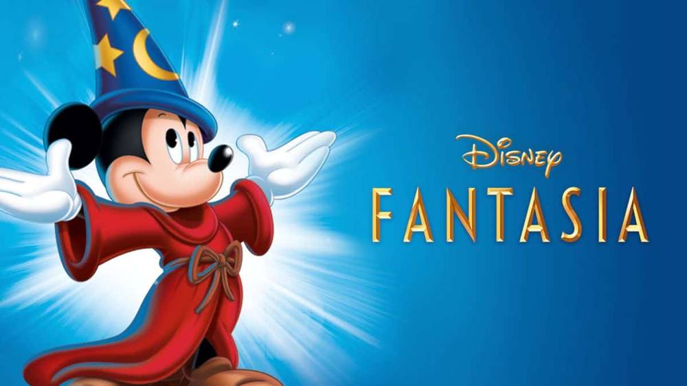 Image promotionnelle pour "Fantasia" de Disney mettant en vedette Mickey Mouse habillé en apprenti sorcier dans une robe rouge et un chapeau de sorcier bleu, sur un fond bleu brillant.