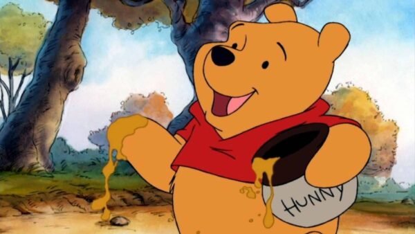 Winnie l'ourson, un ours jaune joyeux, tient un pot étiqueté « chéri » avec du miel qui en coule, vêtue d'une chemise rouge, sur un fond de forêt ensoleillée.