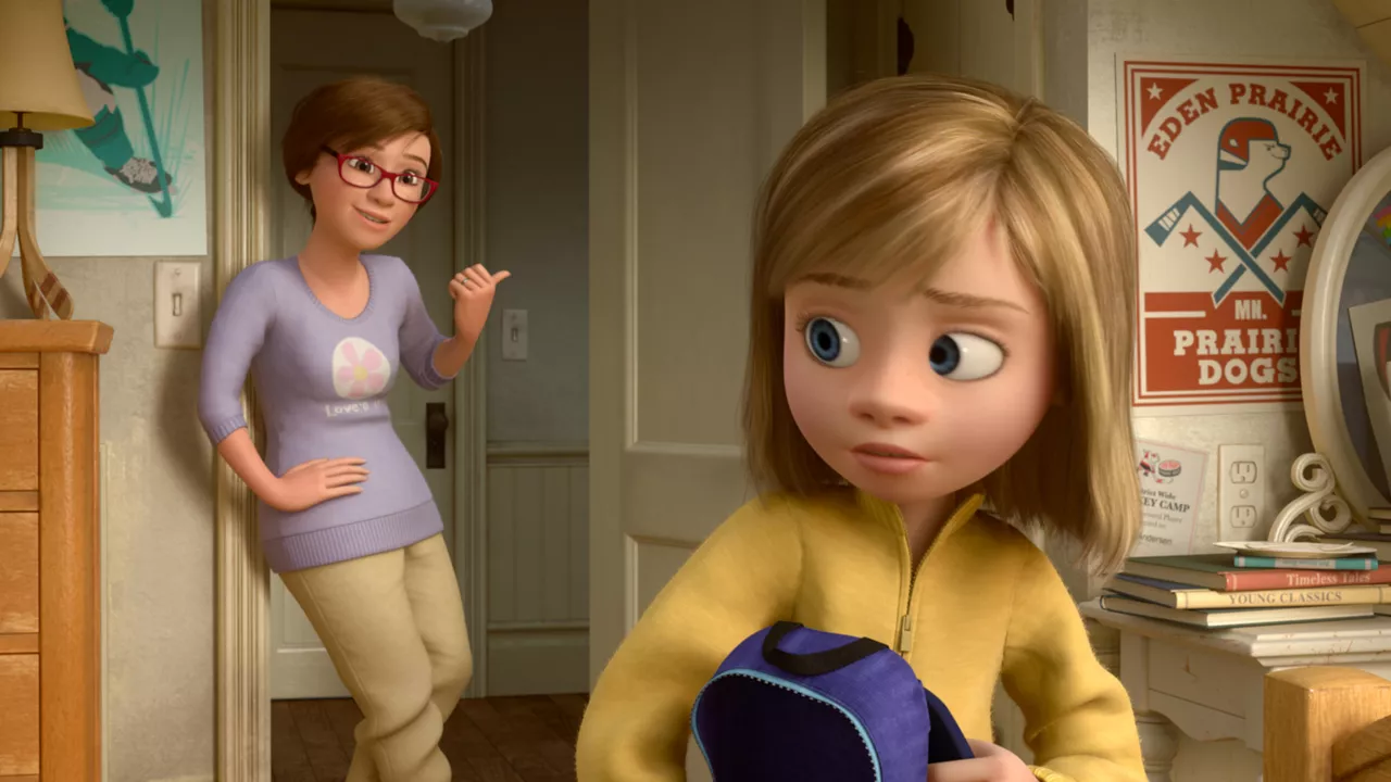 Une image CGI du film d'animation "Inside Out" montrant une jeune fille aux cheveux blonds tenant un sac à dos tandis qu'une femme, vraisemblablement sa mère, se tient dans l'embrasure d'une porte et lui sourit lors de son premier rendez-vous.