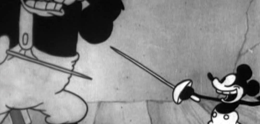 Une image d'animation classique en noir et blanc montrant Mickey Mouse en position d'escrime face au personnage plus grand et menaçant Pat Hibulaire brandissant une épée, les deux personnages semblent conflictuels.
