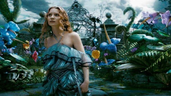 Dans une scène qui rappelle "Alice au pays des merveilles", une femme vêtue d'une robe fluide se tient dans un jardin enchanteur avec des fleurs surdimensionnées d'un bleu vif et des papillons délicats et colorés. Un orn