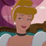 Un personnage animé avec un chignon élégant, vêtu d'une robe couleur pêche et de boucles d'oreilles en perles, sourit doucement, assis sur un fond violet au décor de fanfare.