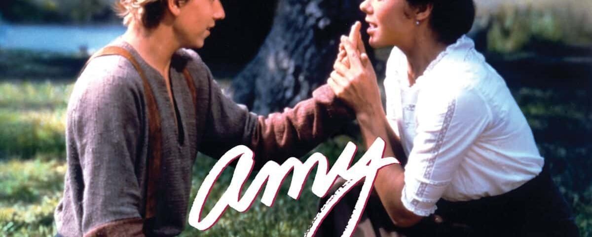 Un jeune homme et une femme se tiennent la main et se regardent sous un arbre. L'image a un éclairage doux et une sensation romantique, avec le mot « Amy » superposé en cursive rose.