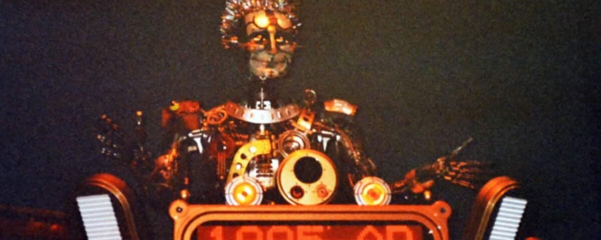 Un robot futuriste avec des détails complexes et des éléments lumineux, étiqueté "The Timekeeper 1995 ad", dans un décor faiblement éclairé.