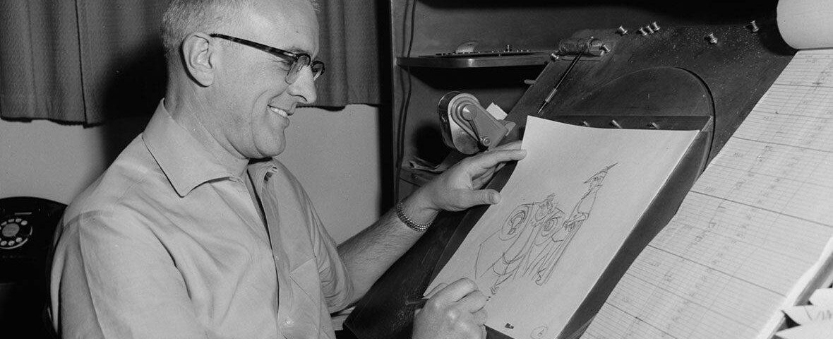 Un homme souriant portant des lunettes dessinant sur une table à dessin, tenant un crayon et regardant le croquis d'un personnage animé de Milt Kahl.