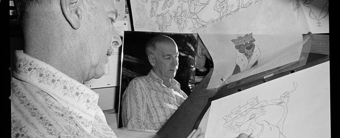 Un homme dessine un personnage de dessin animé sur un bureau à dessin, entouré d’autres illustrations. L'accent est mis sur son dessin à la main et le reflet de son visage dans un miroir, évoquant le style d'Oll.