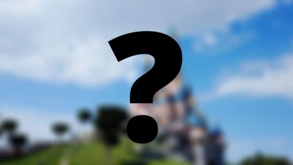 Une image floue des attractions du château sous un ciel bleu clair, avec un grand point d'interrogation noir superposé au premier plan.