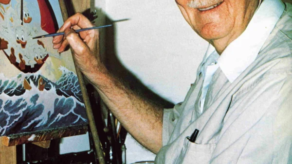 Homme âgé avec des lunettes et une casquette, souriant en peignant une scène maritime colorée sur une toile dans un studio bien éclairé, rappelant le style de Carl Barks.