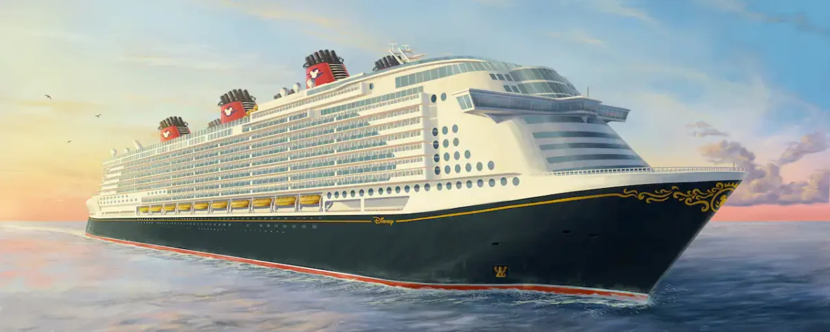Un grand navire Disney Cruise Line naviguant sur une mer calme au coucher du soleil, avec un ciel doré et des nuages duveteux en arrière-plan.