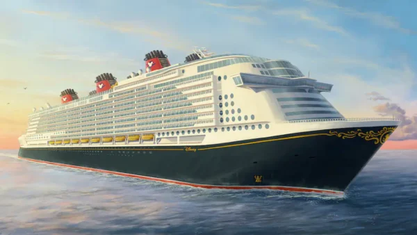 Un grand navire Disney Cruise Line naviguant sur une mer calme au coucher du soleil, avec un ciel doré et des nuages duveteux en arrière-plan.
