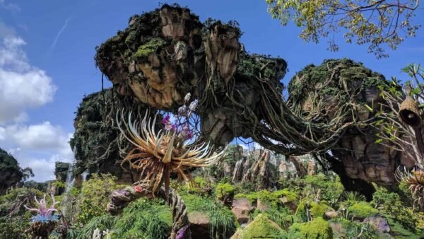 Montagnes flottantes au-dessus d'un paysage luxuriant et vibrant avec des plantes exotiques sous un ciel bleu clair, rappelant les scènes d'Avatar.