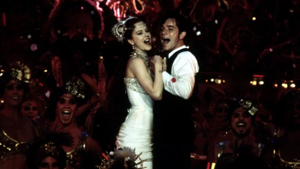 Une scène joyeuse mettant en scène une femme en robe blanche et un homme en smoking dansant en étroite collaboration parmi un groupe d'artistes excités aux costumes vibrants au Moulin Rouge.