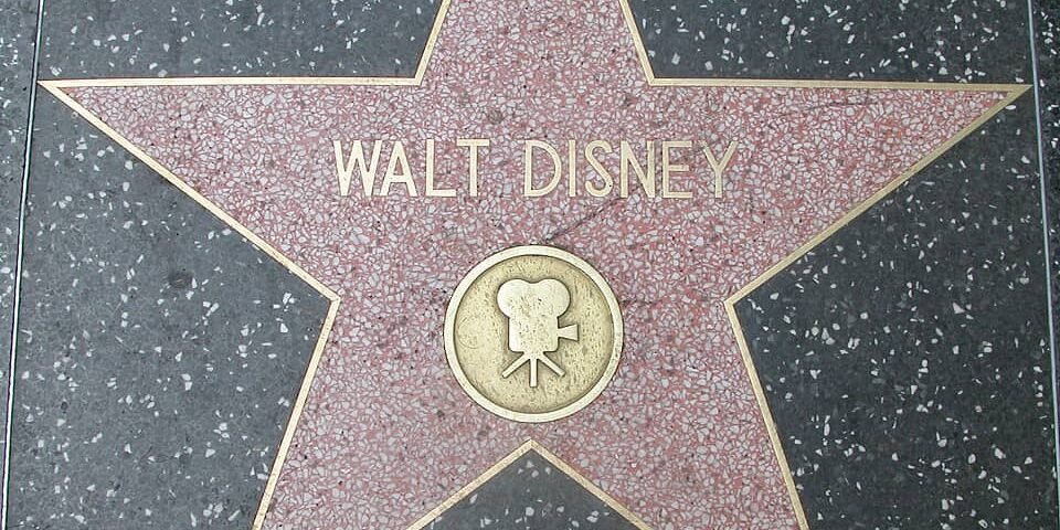 Une vue rapprochée de l'étoile de Walt Disney sur le Hollywood Walk of Fame, avec son nom et une icône de Mickey Mouse au centre.