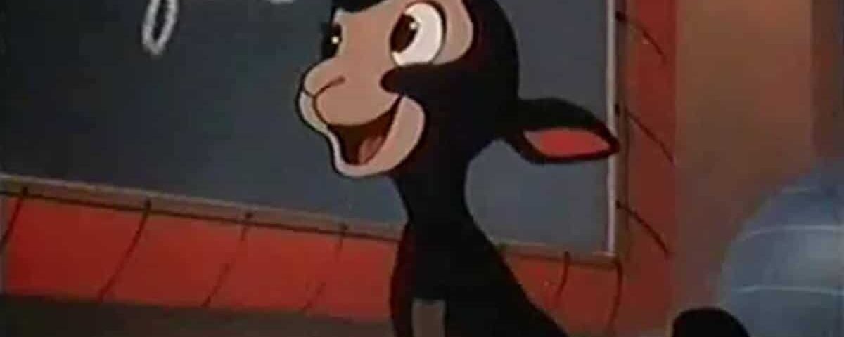 Image de bande dessinée représentant un âne anthropomorphe heureux debout devant un tableau noir avec les mots partiellement visibles « Danny le petit mouton noir » écrits à la craie.