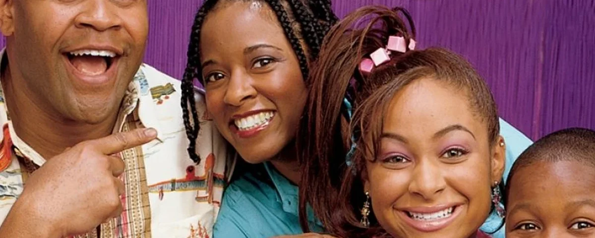 Une famille de quatre personnes, composée d'un père, d'une mère, d'une fille et d'un fils de "Phénomène Raven", souriant joyeusement ensemble sur fond violet. Les parents sont à l'arrière tandis que les enfants