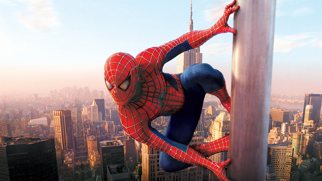 Spiderman, dans son emblématique costume rouge et bleu, escalade un gratte-ciel avec un paysage urbain animé et un ciel dégagé en arrière-plan.