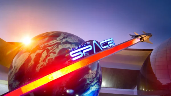 Une image vibrante de l'attraction « Mission Space » à Epcot, Disney World, présentant un grand globe et un modèle de vaisseau spatial avec des lumières rouges et bleues illuminées sous un ciel crépusculaire.