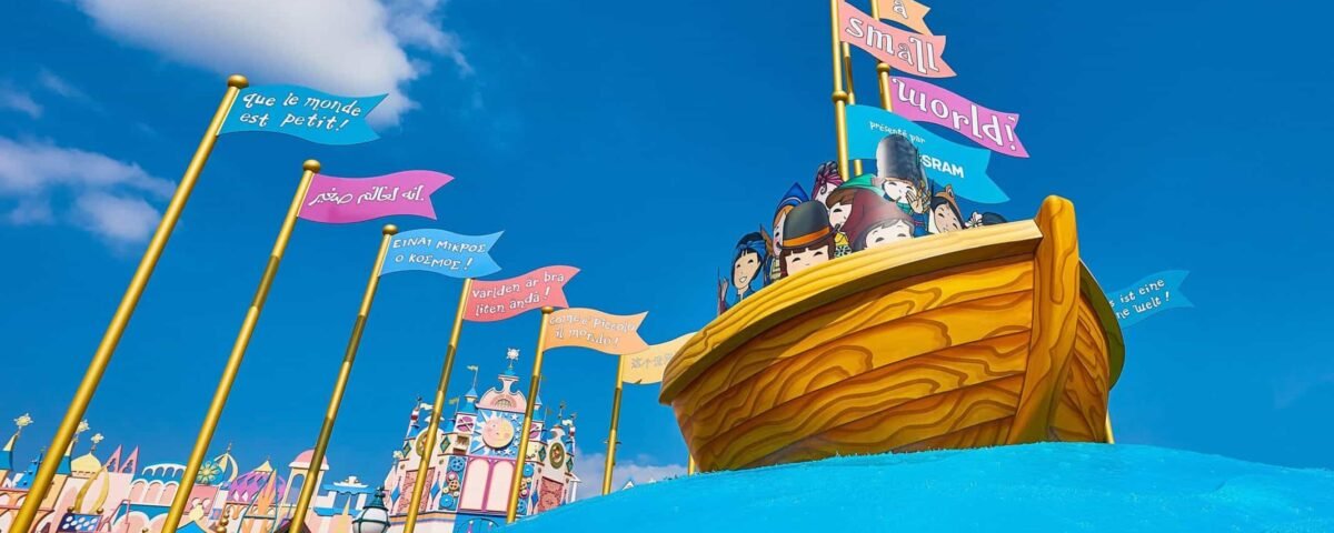 Une scène vibrante et colorée d'un manège dans un parc à thème, inspirée de « Le monde est petit », mettant en vedette un bateau pirate avec des personnages de dessins animés à bord, naviguant sur un ciel bleu vif avec une signalisation fantaisiste et