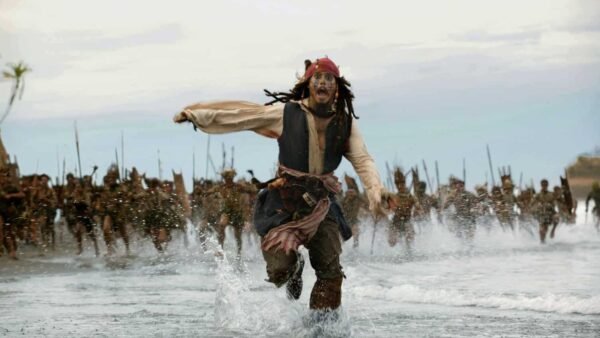 Le capitaine Jack Sparrow courant sur l'eau, poursuivi par une tribu, dans une scène dynamique et urgente de "Pirates des Caraïbes".