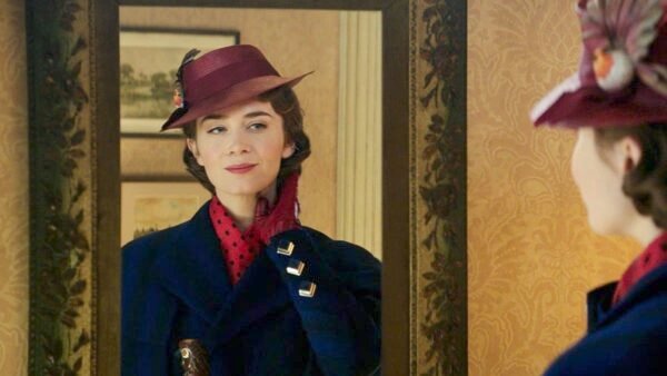 Une femme portant un chapeau marron vintage et un manteau bleu orné d'un foulard rouge regarde son reflet dans un miroir orné, ajustant son foulard avec une expression ravie rappelant "Mary Poppins Returns".