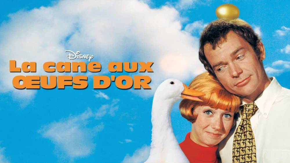 Affiche promotionnelle du film Disney "La Cane aux Oeufs d'Or", mettant en scène un homme et une femme, avec la femme tenant une oie blanche sous un ciel bleu avec
