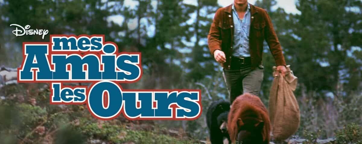 Une image promotionnelle pour le film "Mes Amis les Ours" mettant en scène un homme dans une forêt portant un sac, marchant à côté d'un ours brun. Le logo est visible au premier plan.