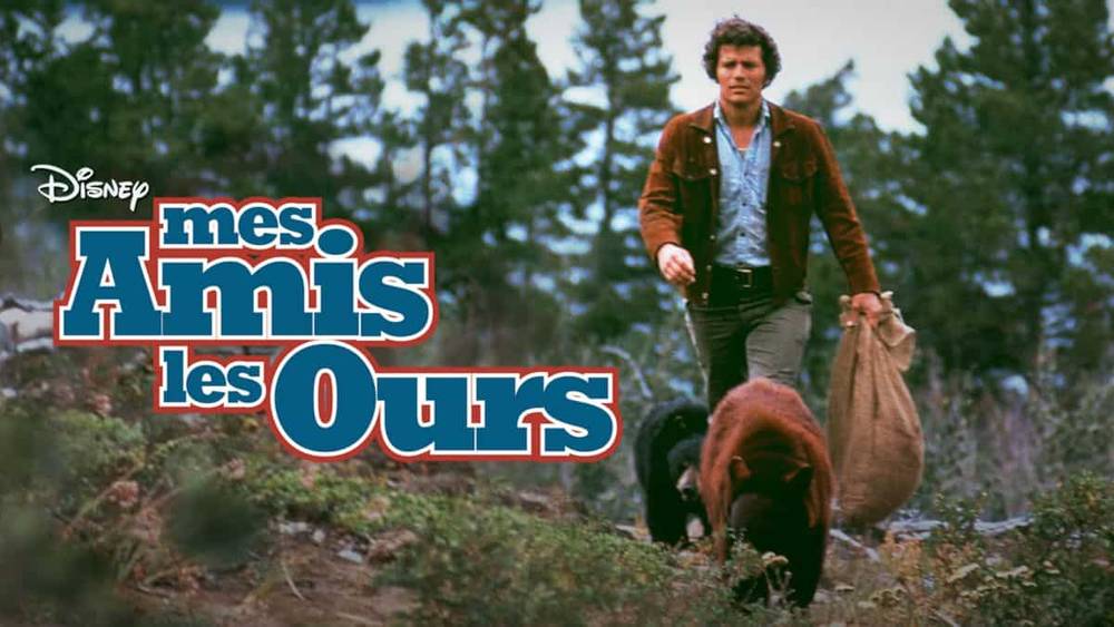 Une image promotionnelle pour le film "Mes Amis les Ours" mettant en scène un homme dans une forêt portant un sac, marchant à côté d'un ours brun. Le logo est visible au premier plan.