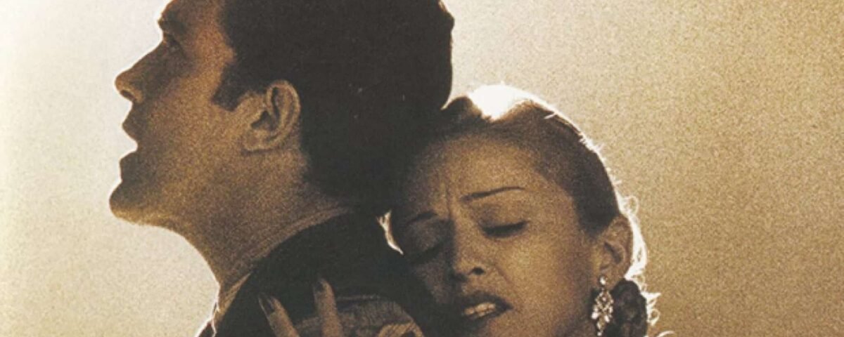 Une image aux tons sépia montrant un homme en uniforme militaire embrassant Evita, qui semble affligée, de dos, tous deux regardant attentivement vers leur gauche.