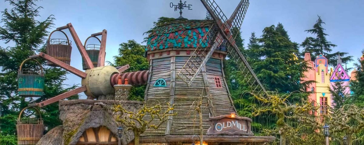 Une scène de parc d'attractions fantaisiste mettant en vedette des pirouettes du vieux moulin avec des outils de jardin ludiques et surdimensionnés et des fleurs colorées, sous un ciel nuageux.