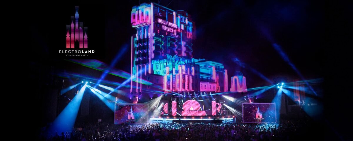 Une scène vibrante à Electroland, Disneyland Paris, montrant une grande foule profitant d'un spectacle de lumière spectaculaire projeté sur la façade d'un château sur le thème de Disney, avec des lasers colorés et des lumières de scène.