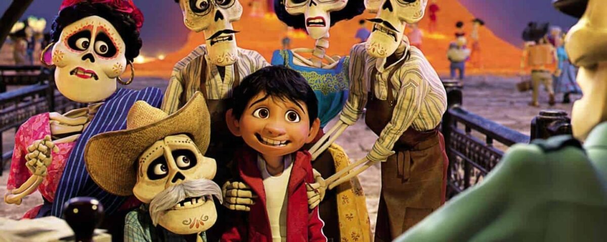 Une scène joyeuse du film Pixar "Coco" mettant en vedette Miguel, entouré de ses ancêtres squelettiques, souriant dans un pays de morts coloré, avec un pont et des pétales de souci brillants au milieu.