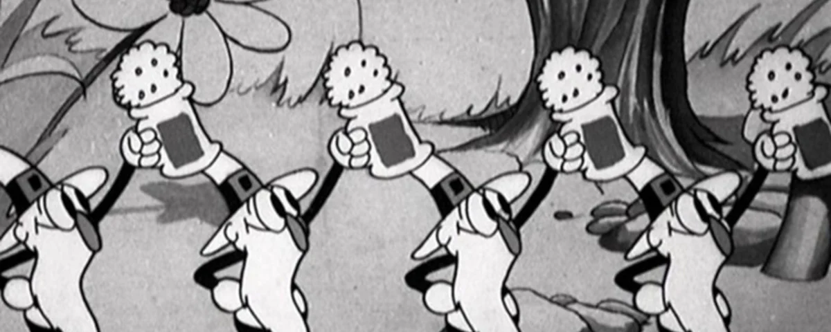 Image animée en noir et blanc tirée de "Silly Symphonies" montrant une file de pissenlits de dessins animés portant des chaussures et des gants, chacun tenant une valise, marchant dans un décor forestier fantaisiste.