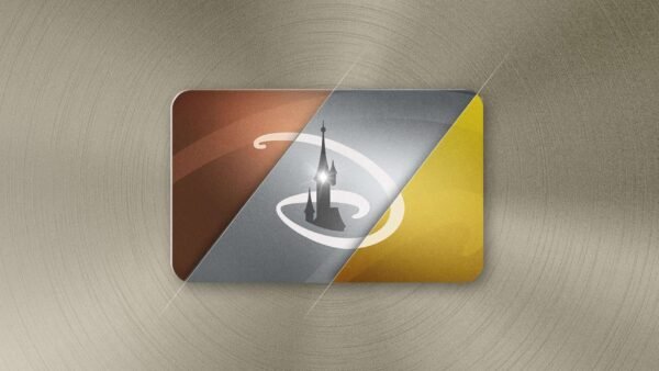 Illustration d'un pass Disneyland Paris stylisé et incliné avec un fond texturé doré et bronze. La carte présente un phare noir sur un champ circulaire gris et jaune.