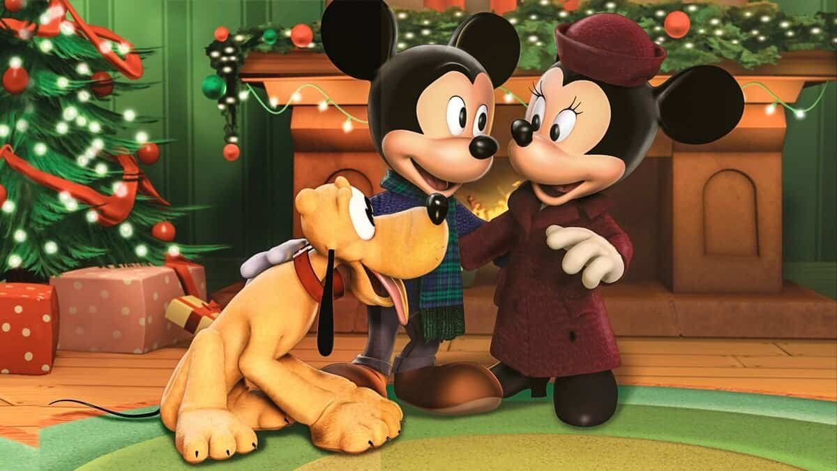 Mickey Mouse et Minnie Mouse dans une salle de fête, se tenant la main avec Pluto le chien à leurs côtés, entourés de décorations et de cadeaux "Il était deux fois Noël".