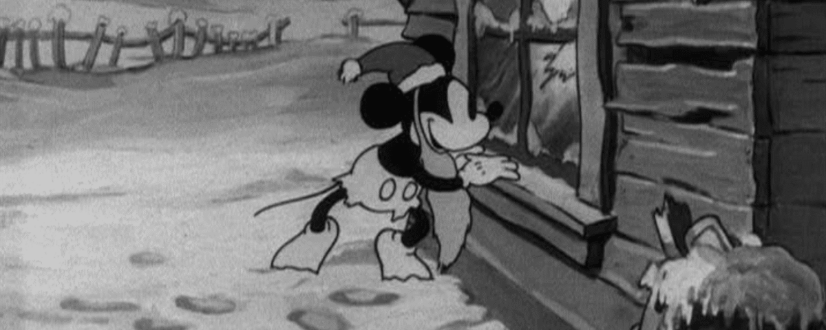 Animation en noir et blanc de Mickey Père Noël portant un foulard, l'air plein d'espoir devant une cabane enneigée, avec des empreintes de pas menant à la porte.