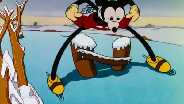 Mickey Mouse patine sur la glace, jambes écartées et bras tendus pour l'équilibre, avec un paysage hivernal en arrière-plan. La neige recouvre une partie du sol et des branches d'arbres.