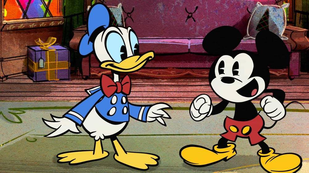 Donald Duck et Mickey Mouse, tous deux personnages animés, se tiennent debout dans une pièce colorée et légèrement échevelée, l'air heureux et gesticulant pendant qu'ils discutent pendant Joyeux Noël.