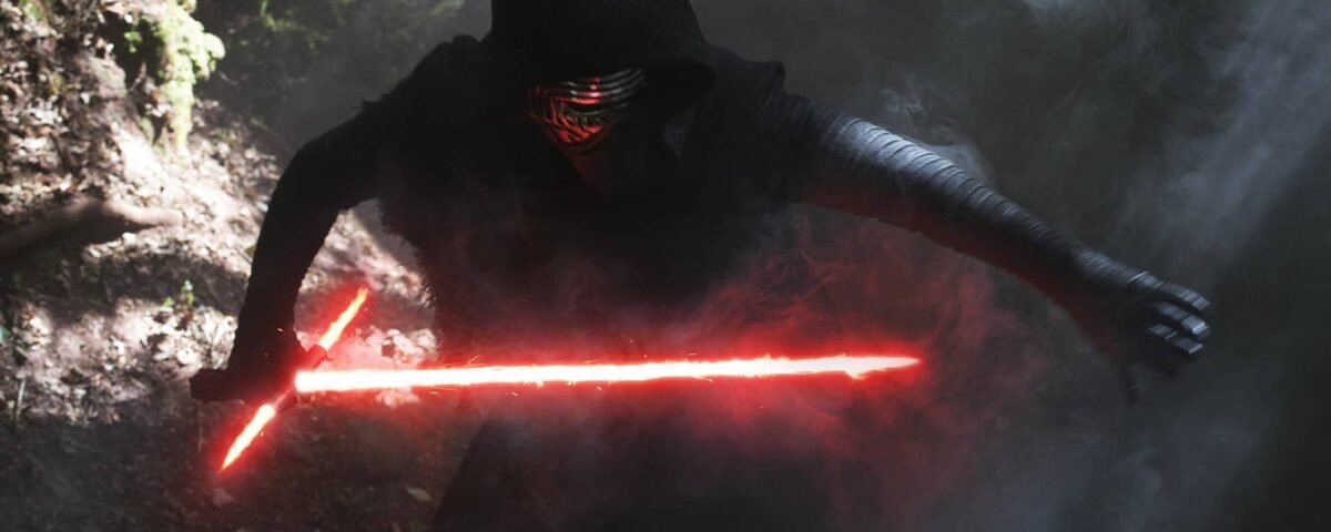 Un personnage vêtu d'une robe noire et d'un masque, identifié comme étant Kylo Ren, brandit un sabre laser rouge allumé dans une forêt brumeuse, dégageant une aura menaçante.
