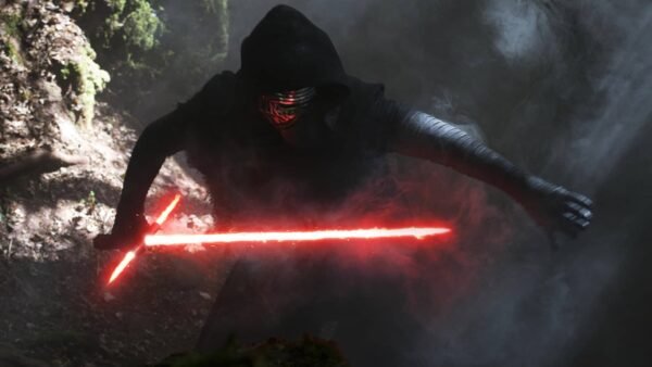 Un personnage vêtu d'une robe noire et d'un masque, identifié comme étant Kylo Ren, brandit un sabre laser rouge allumé dans une forêt brumeuse, dégageant une aura menaçante.