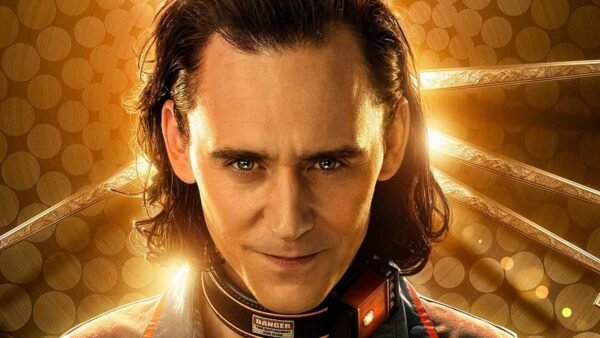Image promotionnelle de Loki, un personnage de Marvel, mettant en vedette Tom Hiddleston avec un sourire narquois malicieux, portant un collier de prison, sur un fond lumineux et orné.