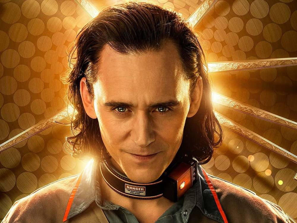 Image promotionnelle de Loki, un personnage de Marvel, mettant en vedette Tom Hiddleston avec un sourire narquois malicieux, portant un collier de prison, sur un fond lumineux et orné.