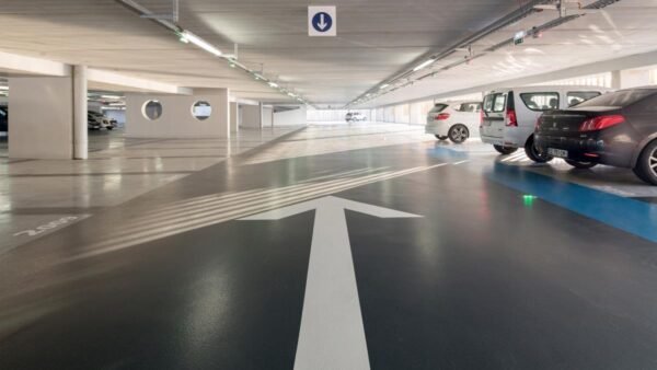 Un parking couvert dans Disney Village avec des voitures garées à l'intérieur.