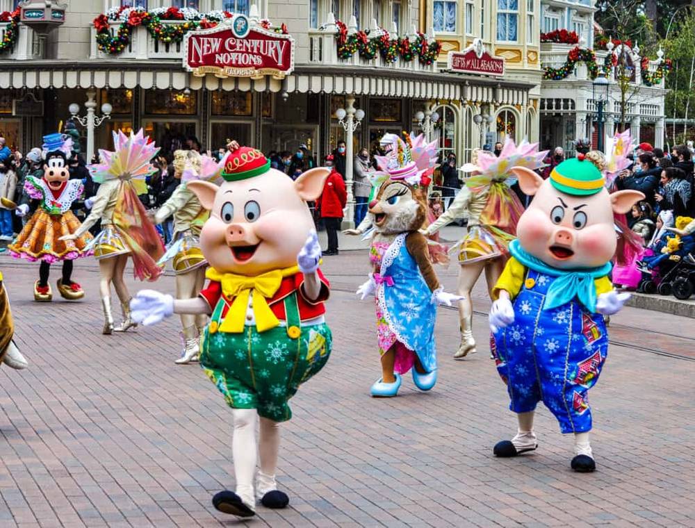 Un défilé festif mettant en vedette un groupe de personnes déguisées en cochons.