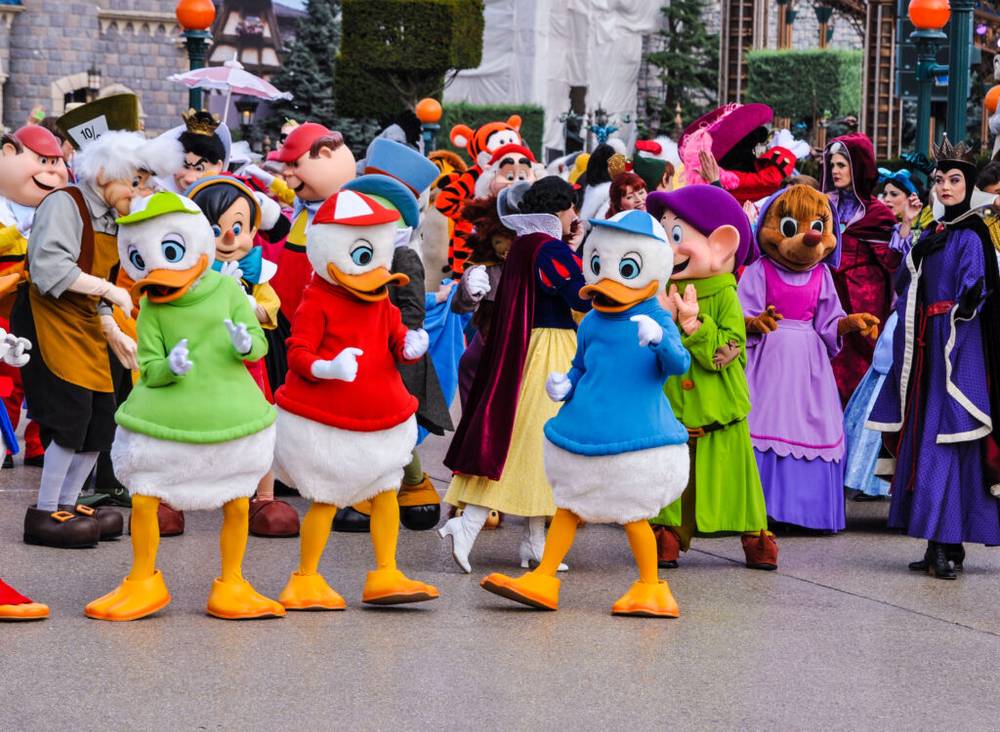 Un groupe de personnes habillées en costumes de Donald Duck déambulant dans Disneyland Paris.